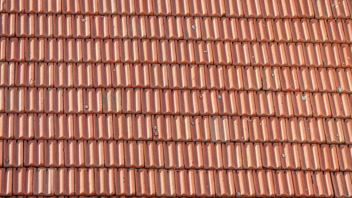 Gedetailleerd uitzicht op overlappingen van klei-tile die een textuurpatroon creëren op een zonnige dag.