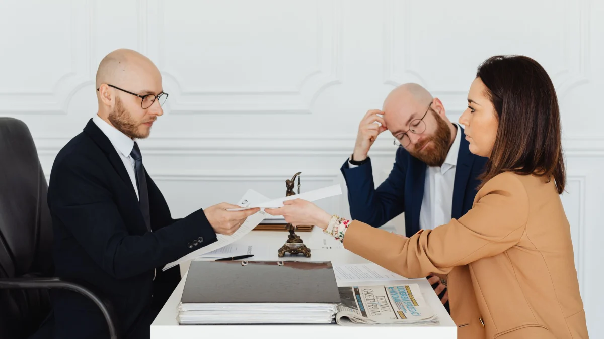 Professionele bijeenkomst met advocaat en cliënten die documenten bespreken in een modern kantoor.